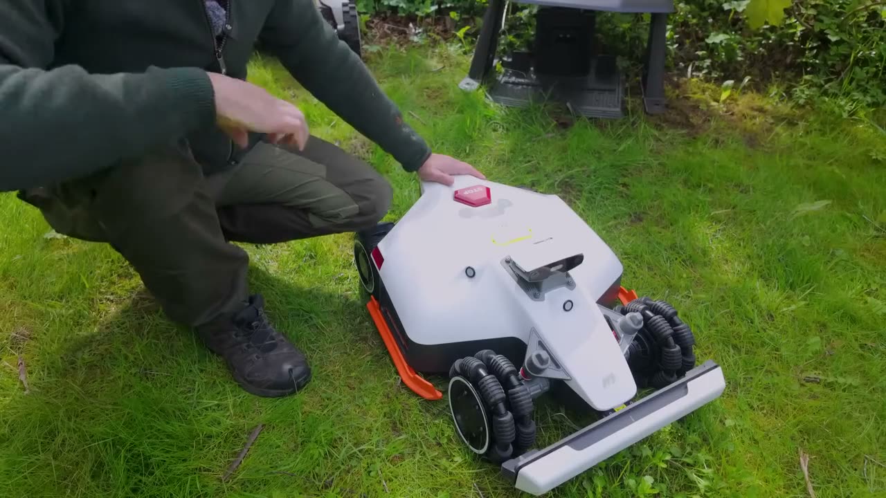 Technician's hands servicing a robotic mower